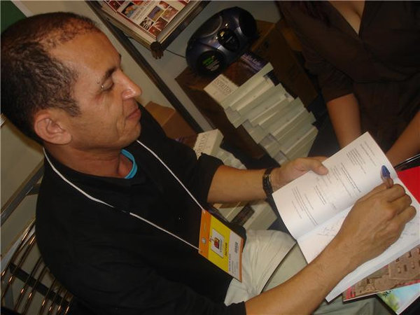 O escritor autografando a antologia de poesias, na Bienal do Livro de São Paulo, edição 2008.